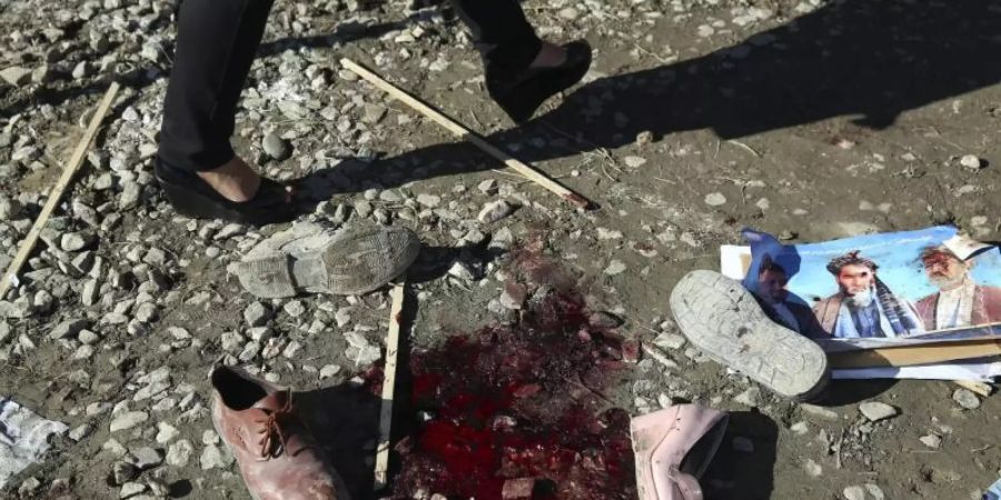 Ein Blutfleck und Schuhe nach einem tödlichen Angriff. Mehr als 100.000 Menschen sind seit Jahresbeginn in Afghanistan vor Kämpfen und Gefechten aus ihren Dörfern und Städten geflohen. Foto: Rahmat Gul/AP/dpa