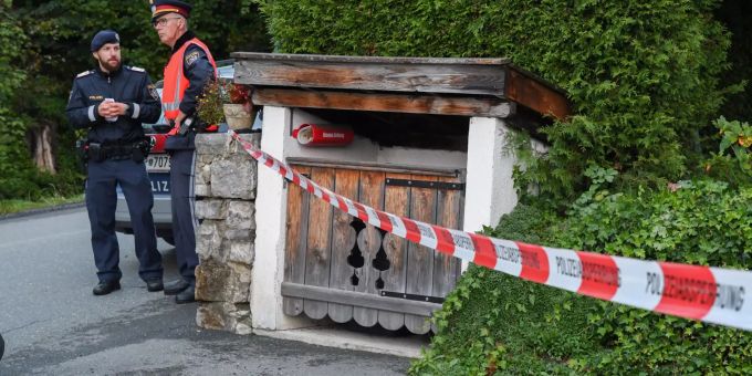 Zwei Polizisten stehen neben einer Absperrung in Kitzbühel. Die Polizei in Österreich ermittelt wegen eines Tötungsdelikts mit fünf Opfern. Kitzbühel Täter