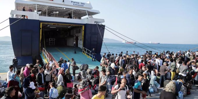 Migranten stehen an einem griechischen Hafen, nachdem sie dort mit einer Fähre angekommen sind. Migranten in Griechenland