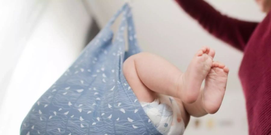 Eine Hebamme wiegt ein Baby