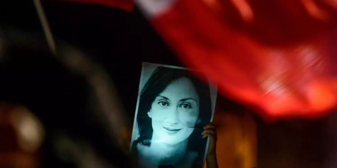 Mit einem Bild der ermordeten Reporterin Daphne Caruana Galizia haben sich Demonstranten vor dem Büro des maltesischen Premierministers postiert. Foto: Str/AP/dpa daphne galizia