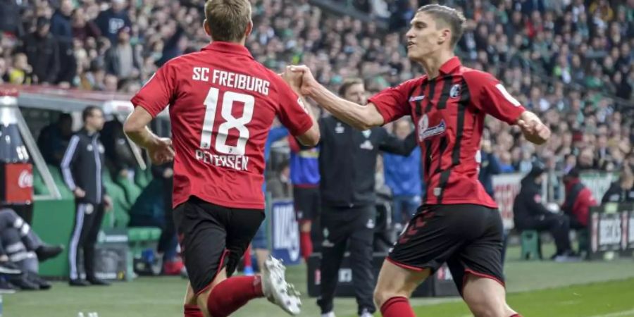 Freiburgs Torschütze Nils Petersen (l) jubelt mit Teamkollege Roland Sallai über den Treffer zum zwischenzeitlichen 1:1. Foto: Axel Heimken/dpa