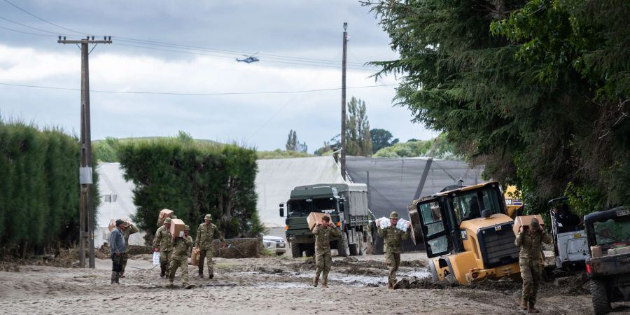 Soldaten der neuseeländischen Streitkräfte bringen Vorräte zum Moteo Marae in der Nähe von Puketapu am Ufer des Tutaekuri-Flusses.