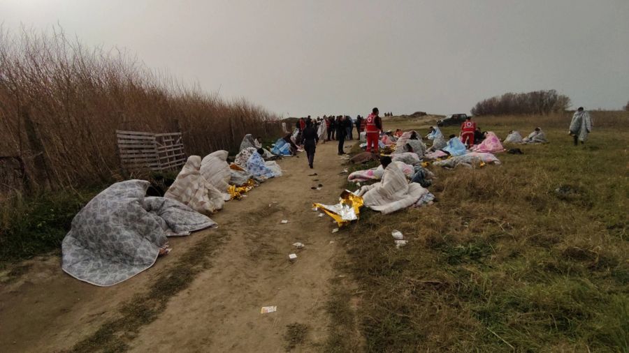 Überlebende werden am Strand in Decken gewickelt und medizinisch versorgt.