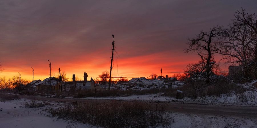 Die Sonne geht über beschädigten Gebäuden in Tschassiw Jar in der Region Donezk auf.