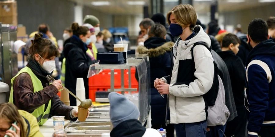 Freiwillige geben in Berlin Essen an Flüchtlinge aus