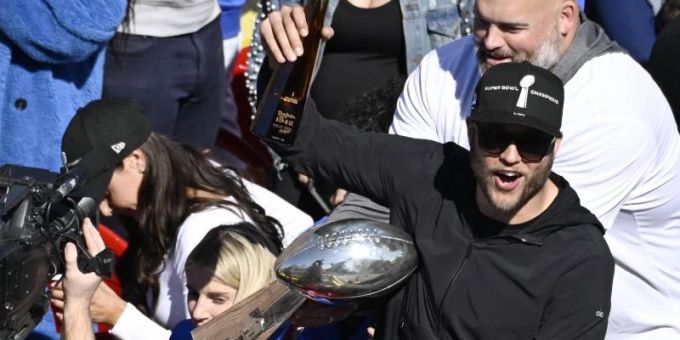 Matthew Stafford (vorn,r), Quarterback der Los Angeles Rams, prostet mit einer Flasche während der Siegesparade in Los Angeles den Fans zu. Foto: Kyusung Gong/AP/dpa Matthew Stafford (vorn,r), Quarterback der Los Angeles Rams, prostet mit einer Flasche während der Siegesparade in Los Angeles den Fans zu. Foto: Kyusung Gong/AP/dpa