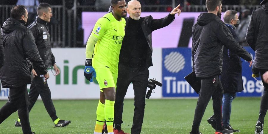 Mailands Keeper Mike Maignan (M) verlässt mit Trainer Stefano Pioli den Platz.