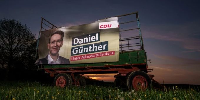 Wahlplakat mit Daniel Günther auf einem Feld Wahlplakat mit Daniel Günther auf einem Feld