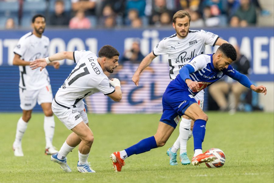 Mohamed Dräger vom FC Luzern wird gleich von zwei Servette-Spielern angegriffen.