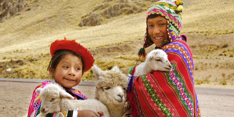 Zwei perunaische Kinder mit Lamas.