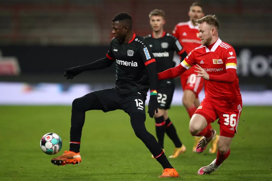 Edmund Tapsoba (l.) von Bayer Leverkusen im Duell mit Union Berlins Cedric Teuchert (r.).