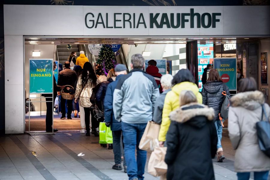 Zahlreiche Passanten mit Masken stehen in einer Einkaufsstrasse in der Innenstadt in einer Schlange vor einer Filiale von Galeria Kaufhof. Ab Mittwoch tritt in Bayern der harte Lockdown in Kraft, mit dem auch der Einzelhandel in der Innenstadt schliessen muss.