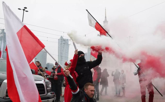 Menschen nehmen mit Fahnen und Fackeln am Unabhängigkeitsmarsch teil. Unabhängigkeitstag in Warschau