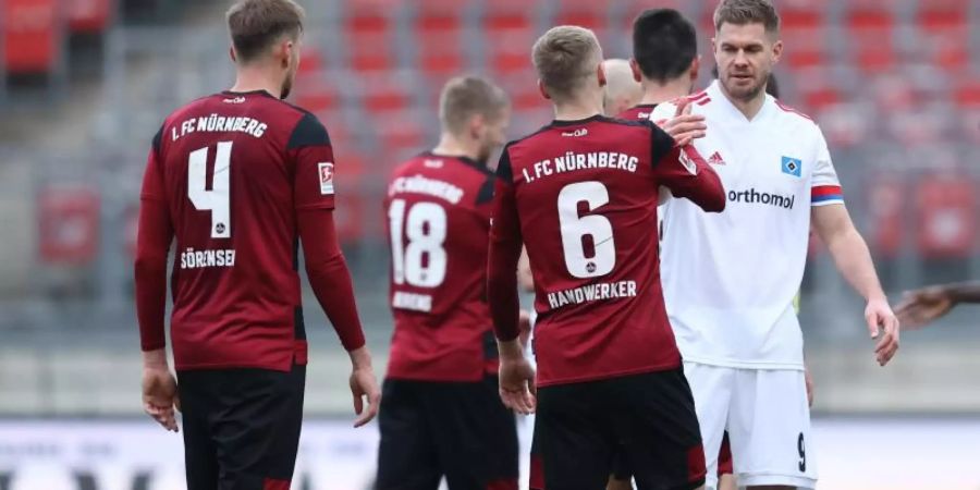 Simon Terodde vom HSV (r) nach dem Spiel beim Handschlag mit Tim Handwerker (6) vom FC Nürnberg. Foto: Daniel Karmann/dpa