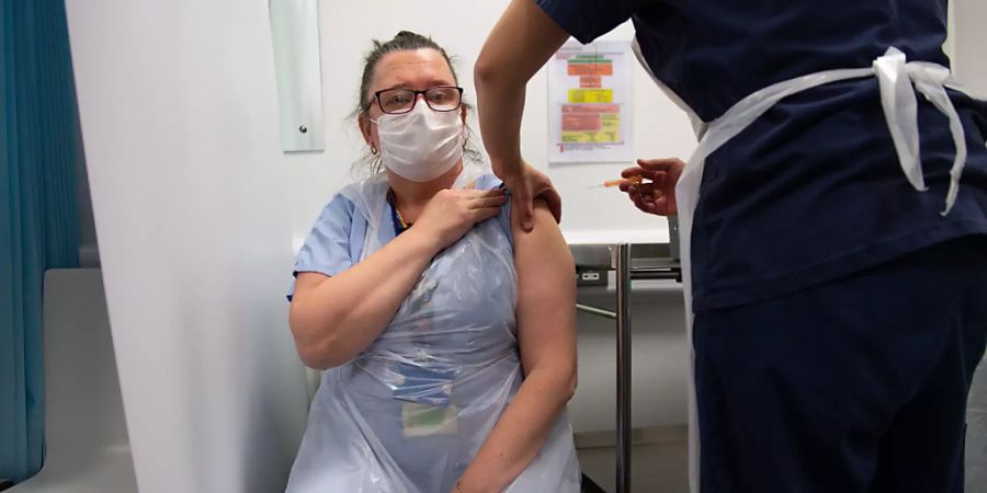 Die Pflegekraft Sue Toye wird im Gesundheitszentrum von Coventry mit dem Impfstoff der Universität Oxford und des Pharmakonzerns AstraZeneca gegen das Coronavirus geimpft. Foto: Jacob King/PA Wire/dpa