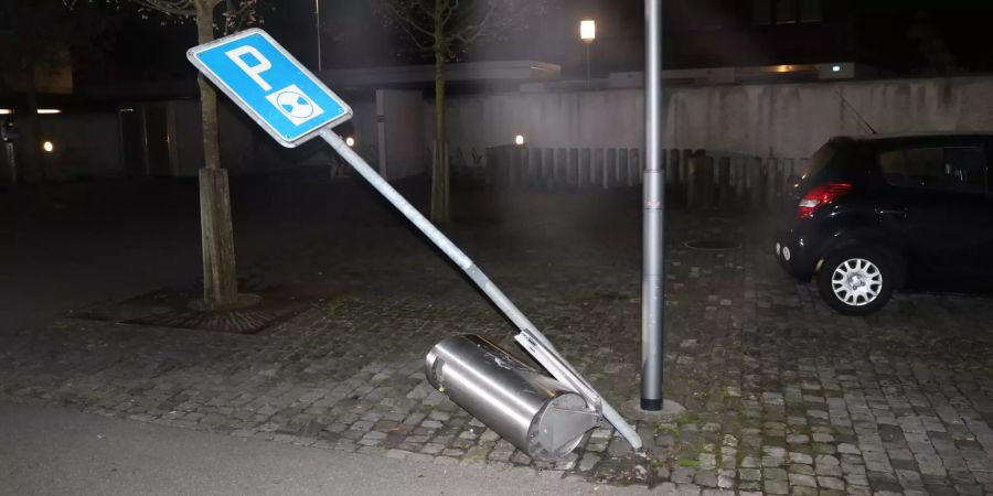 Angefahrenes Verkehrsschild und Abfalleimer