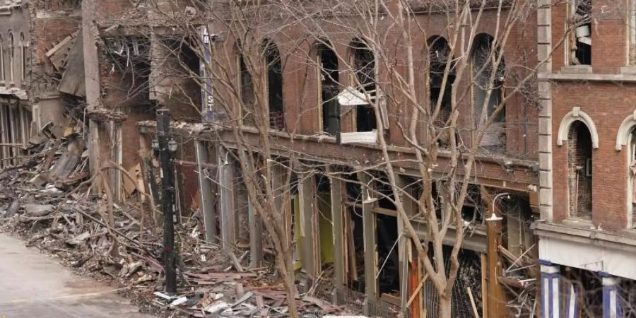Ein Fahrzeug, das bei einer Explosion am Weihnachtstag zerstört wurde, steht in den Trümmern, die auf der Strasse liegen. Foto: Mark Humphrey/AP/dpa