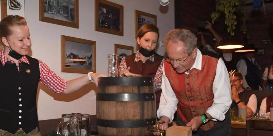 Christian Ude zapft im Schiller Bräu mit zwei Schlägen an. Foto: Felix Hörhager/dpa