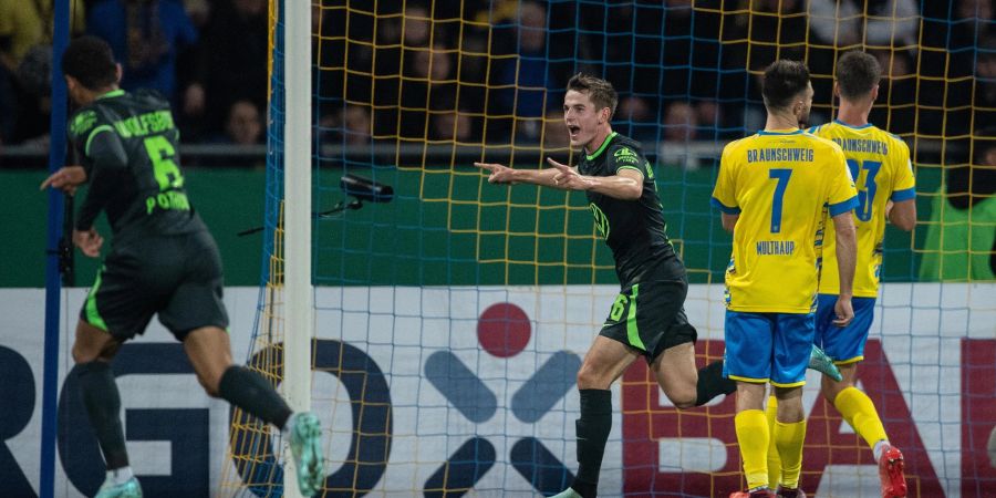 Der Wolfsburger Jakub Kaminski (M.) feiertseinen Siegtreffer.