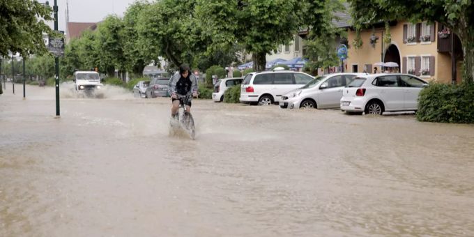 Ein Radfahrer fährt durch Hochwasser, nachdem ein Gewitter zu Überschwemmungen geführt hat, in Muttenz BL, am Samstag, 25. Juni 2016. Muttenz