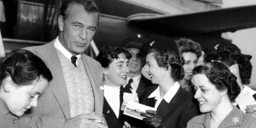 Der US-amerikanische Schauspieler Gary Cooper 1953 zu Besuch in Deutschland - umlagert von Verehrerinnen. Foto: Heinz Bogler/dpa