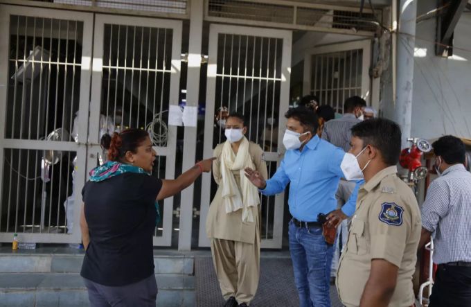 Eine Angehörige eines Corona-Patienten streitet mit den Pflegepersonal vor einem Spital in Indien. Coronavirus in Indien