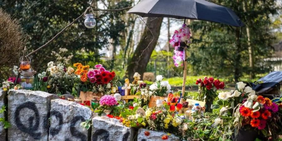 Blumen erinnern im Wollepark in Delmenhorst an einen verstorbenen 19-Jährigen. Für die Familie sind die Umstände seines Todes nach einem Polizeieinsatz aufklärungsbedürftig. Foto: Sina Schuldt/dpa