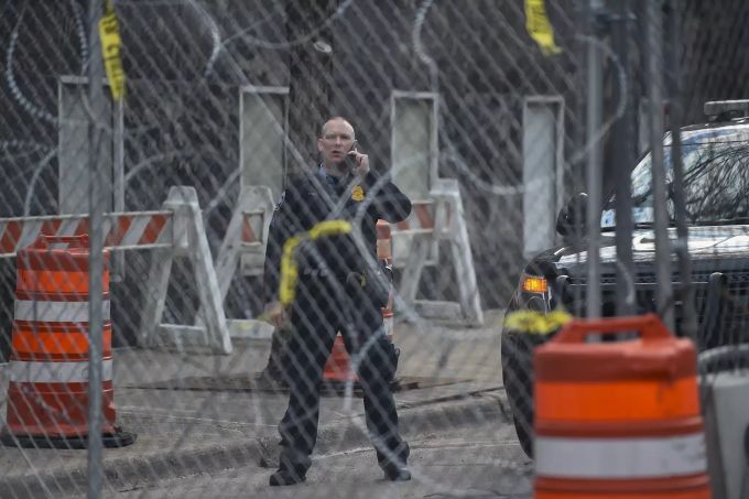 Ein Polizeibeamter hinter einem Zaun mit Stacheldraht beobachtet, wie Demonstranten durch die Straßen marschieren, nachdem die Anwälte ihre Schlussplädoyers beendet haben. Derek Chauvin Trial