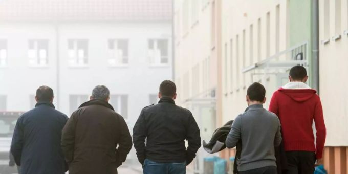 Männliche Asylbewerber gehen über das Gelände der Zentralen Ausländerbehörde (ZABH). (Symbolbild) Asylbewerber