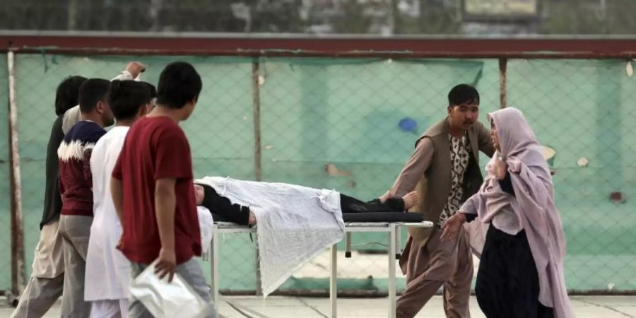 Ein Schüler wird in ein Krankenhaus gebracht. Bei den Opfern soll es sich um Zivilisten handeln. Foto: Rahmat Gul/AP/dpa
