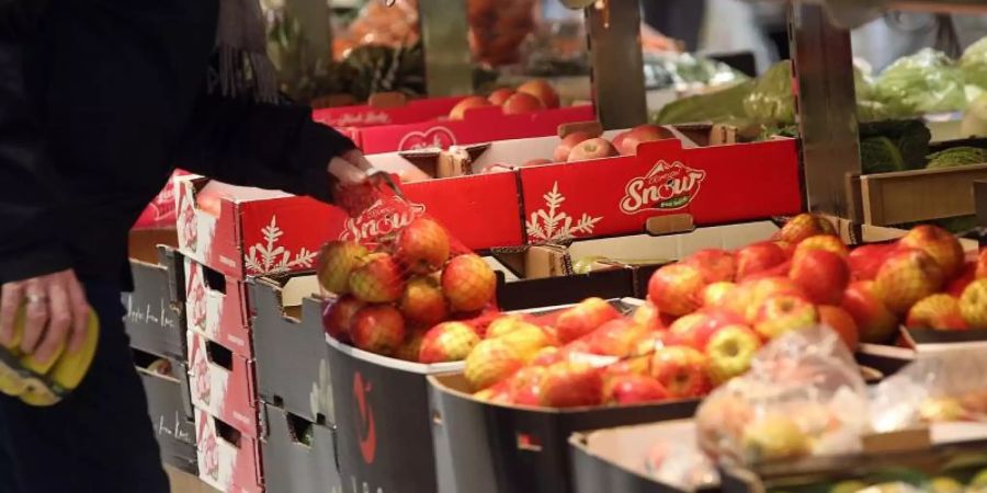 Ein Mann kauft in einem Berliner Supermarkt Obst ein. Foto: Wolfgang Kumm/dpa