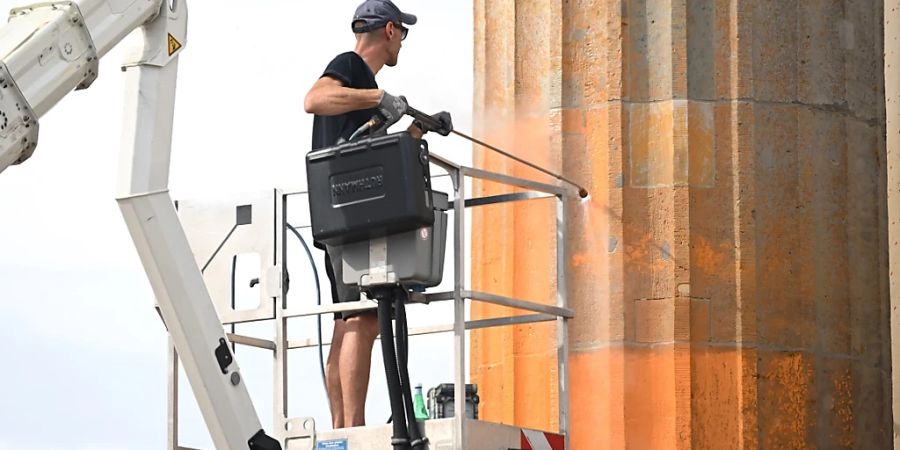 dpatopbilder - Reinigungsarbeiten nach einem Farbanschlag der so genannten letzten Generation auf das Brandenburger Tor. Foto: Britta Pedersen/dpa