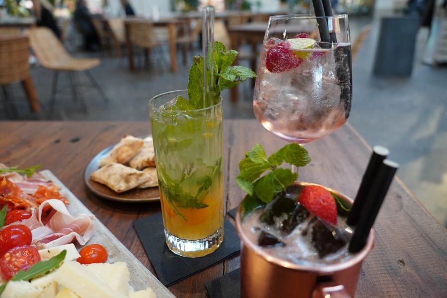 Zum reichhaltigen Apero-Plättli passen der Berry Balsamico Sour (rechts) und der Wildberry Lillet (hinten) hervorragend.