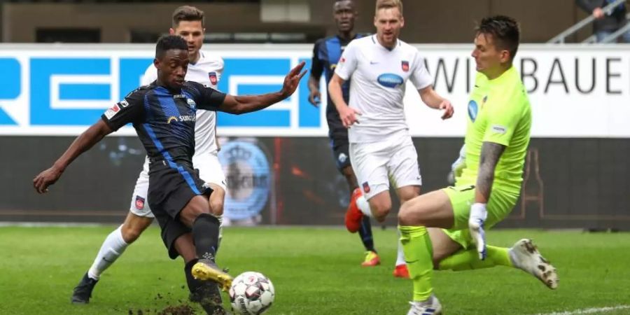 Paderborns Christopher Antwi-Adjej (l) erzielt das 2:0 gegen Heidenheim-Torwart Kevin Müller (r). Foto: Friso Gentsch/dpa