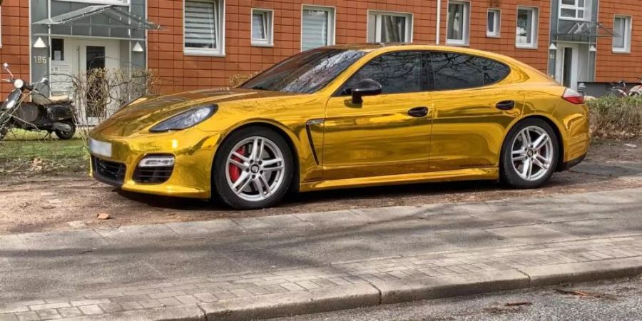 Der mit Goldfolie beklebte Porsche Panamera auf einem Seitenstreifen in Hamburg. Foto: Marius Roeer