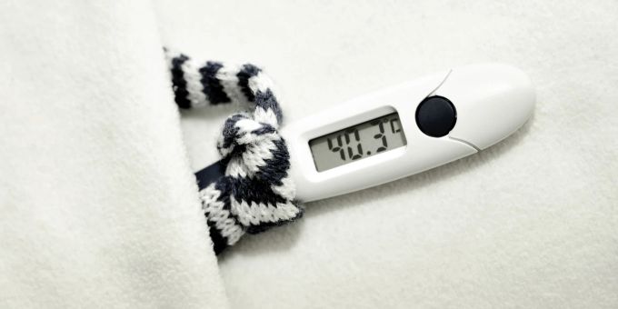 Ein Fieberthermometer auf einer Unterlage aus Stoff. Grippe