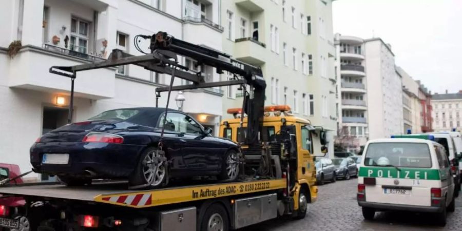 Grosseinsatz gegen eine mutmasslich kriminelle arabische Grossfamilie: Ein Porsche Cabrio wird im Berliner Bezirk Neukölln abtransportiert. Foto: Gregor Fischer