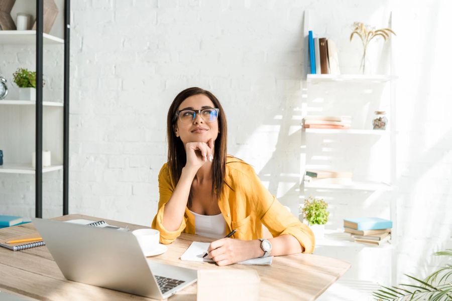 Frau sitzt in einem attraktiven Homeoffice