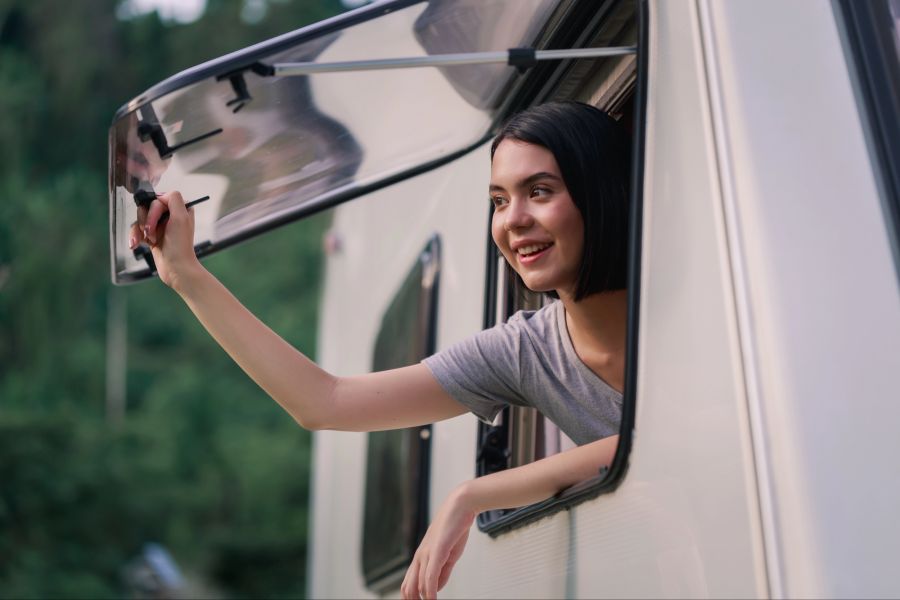 Frau am Fenster eines Wohnmobils