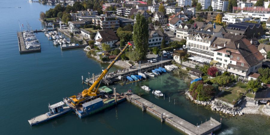 Mittels Pneukran verschieben Arbeiter eine Hafenmole in Meilen. Wegen des tiefen Wasserstands des Zürichsees lag diese auf einem Pfahlstummel auf und hätte beschädigt werden können.