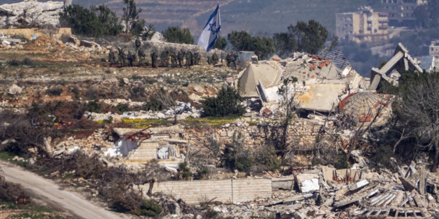 ARCHIV - Israelische Soldaten stehen neben einer israelischen Flagge in einem Dorf im Südlibanon, aufgenommen im Norden von Israel. Foto: Ariel Schalit/AP/dpa