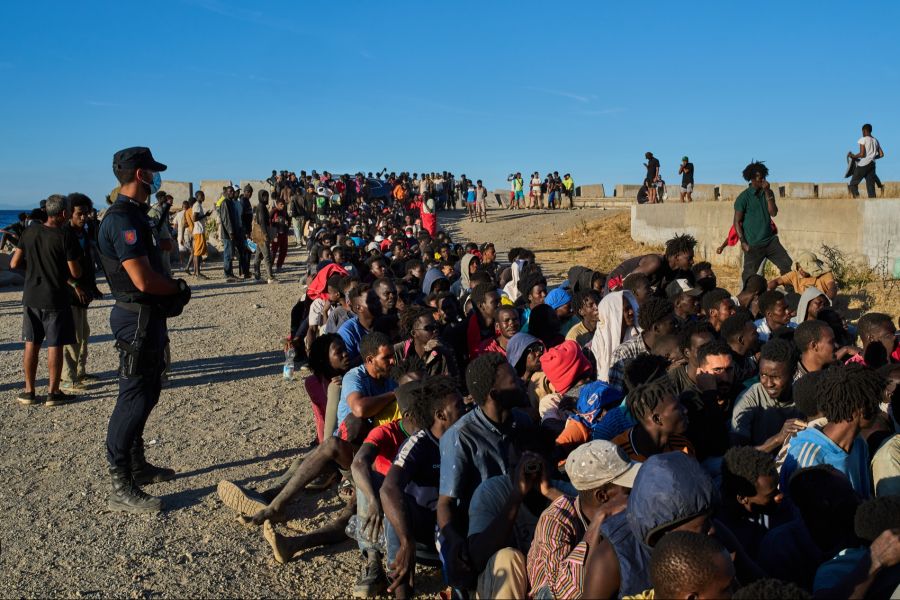 Migranten stehen an einem Strand in Ceuta Schlange, um Lebensmittel zu erhalten. (Bild aufgenommen am Montag, 3. August 2026)