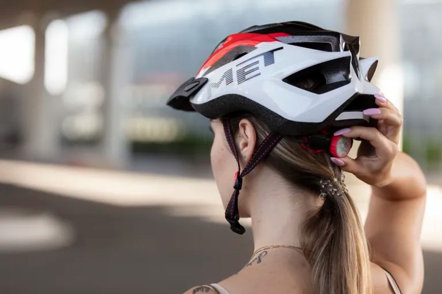 Den Helm hinten mit dem Verstellrad anziehen, bis er bei bei geöffnetem Kinnband fest sitzt, ohne zu wackeln.
