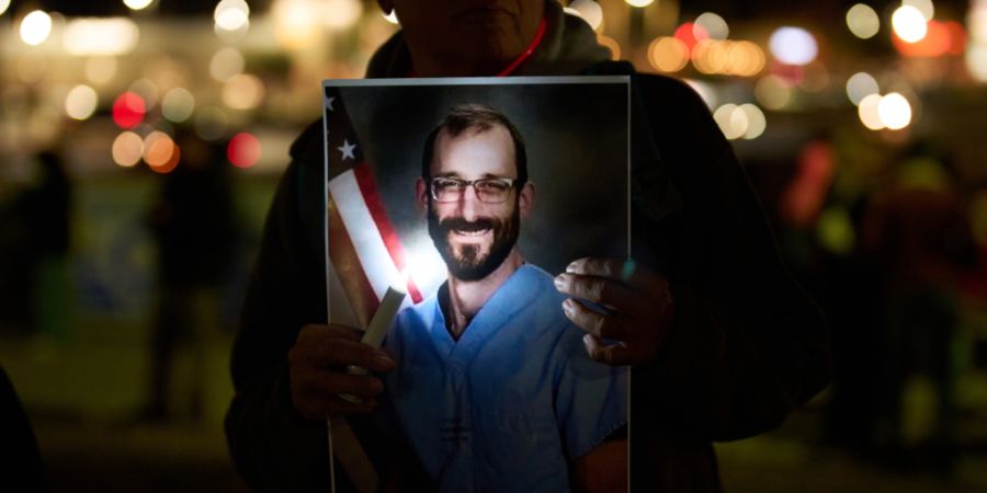 Menschen halten Fotos während einer Mahnwache für Alex Pretti hoch, der von Bundesbeamten in Minneapolis erschossen wurde. Foto: John Locher/AP/dpa