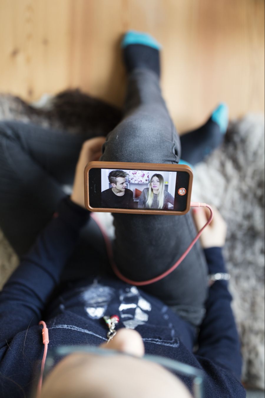 Eine junge Frau schaut sich ein YouTube-Video auf ihrem Smartphone an.