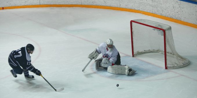 Zwei- und einhändig, Vor- und Rückhand: Der Torhüter muss so schnell wie flexibel auf Angriffe agieren können. (Symbolbild) Tor Eishockey Spieler Puck