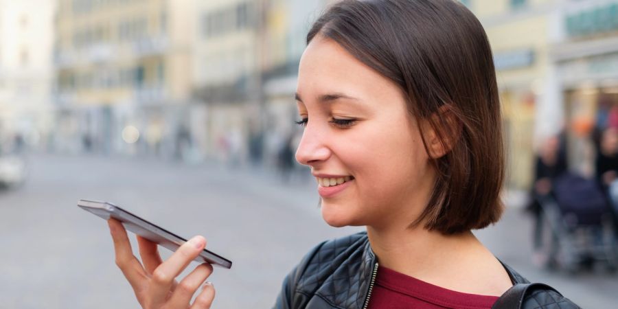 Frau nutzt die Sprachsuche ihres Smartphones