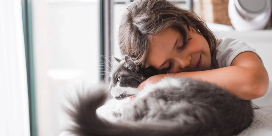 Frau schmiegt sich an eine Katze