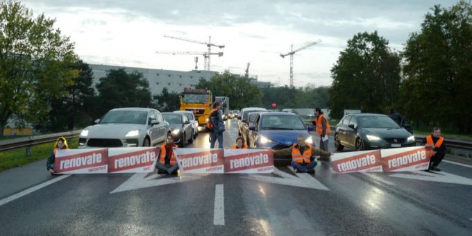 Aktivisten von Renovate Switzerland blockieren eine Autobahnausfahrt nahe Lausanne. klimakleber